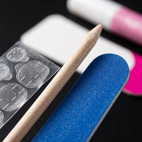 Blue nail tip and wooden applicator with alcohol pad and nail guide sheet
