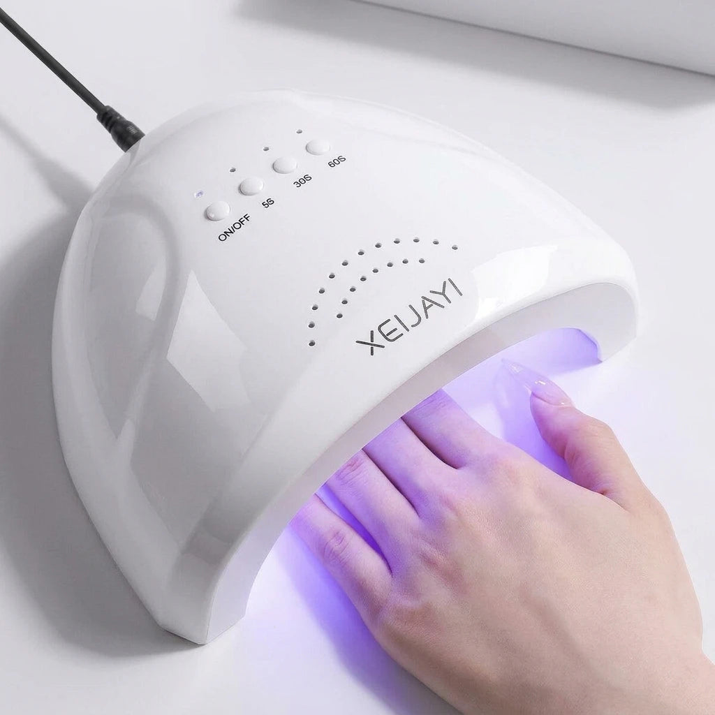 UV nail lamp casting purple light as hand rests under the hood