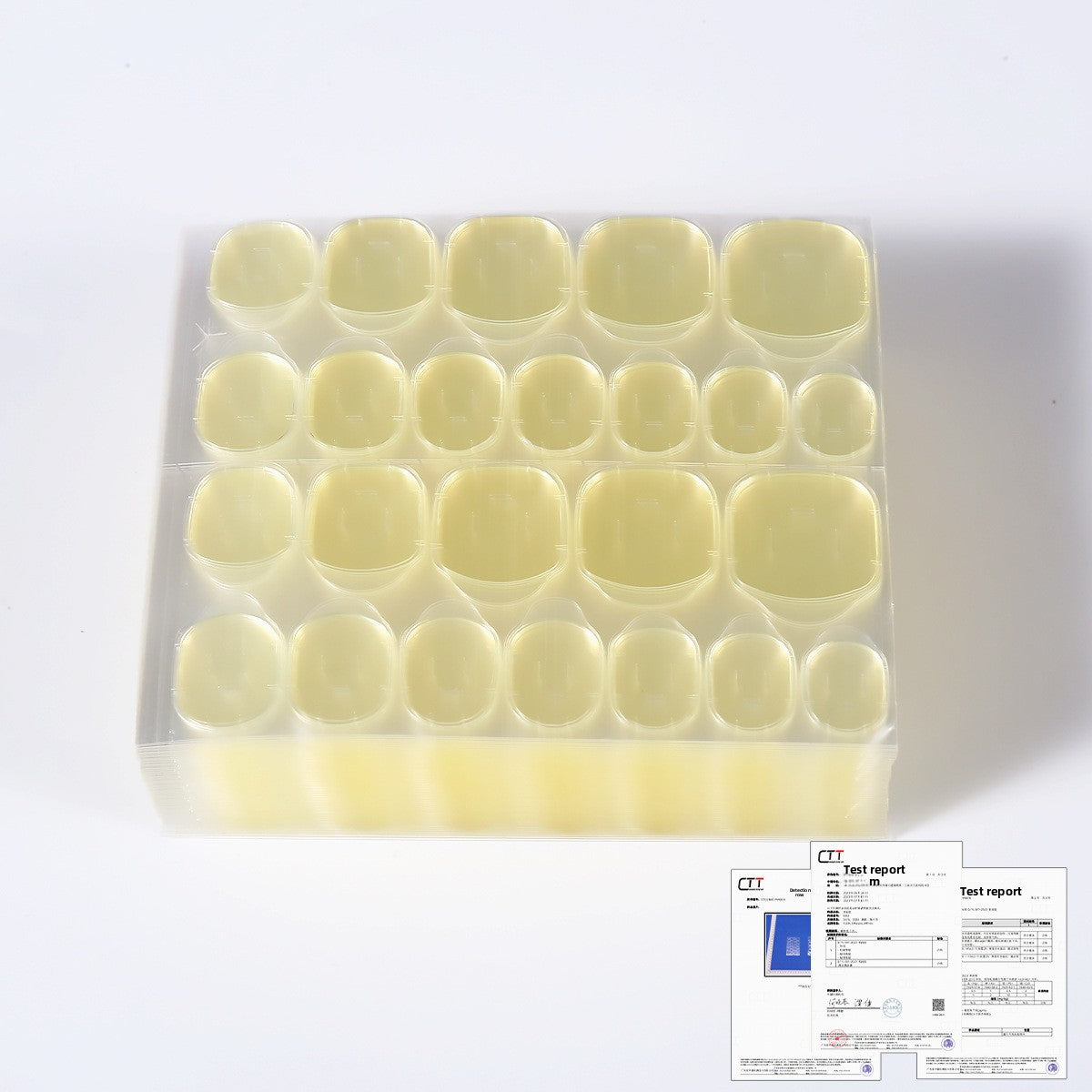 Yellow press-on nail tips in a clear storage tray
